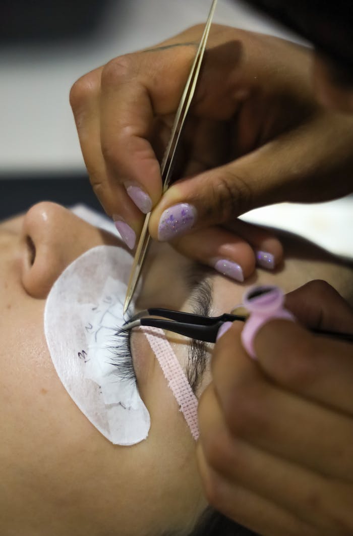 A detailed view of eyelash extension application showing precise technique in a beauty salon.